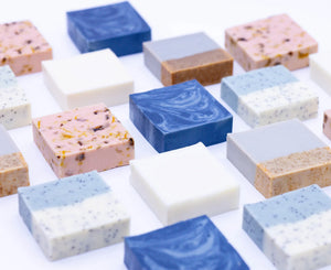 Assorted bars of soap in various colors and textures on a white background